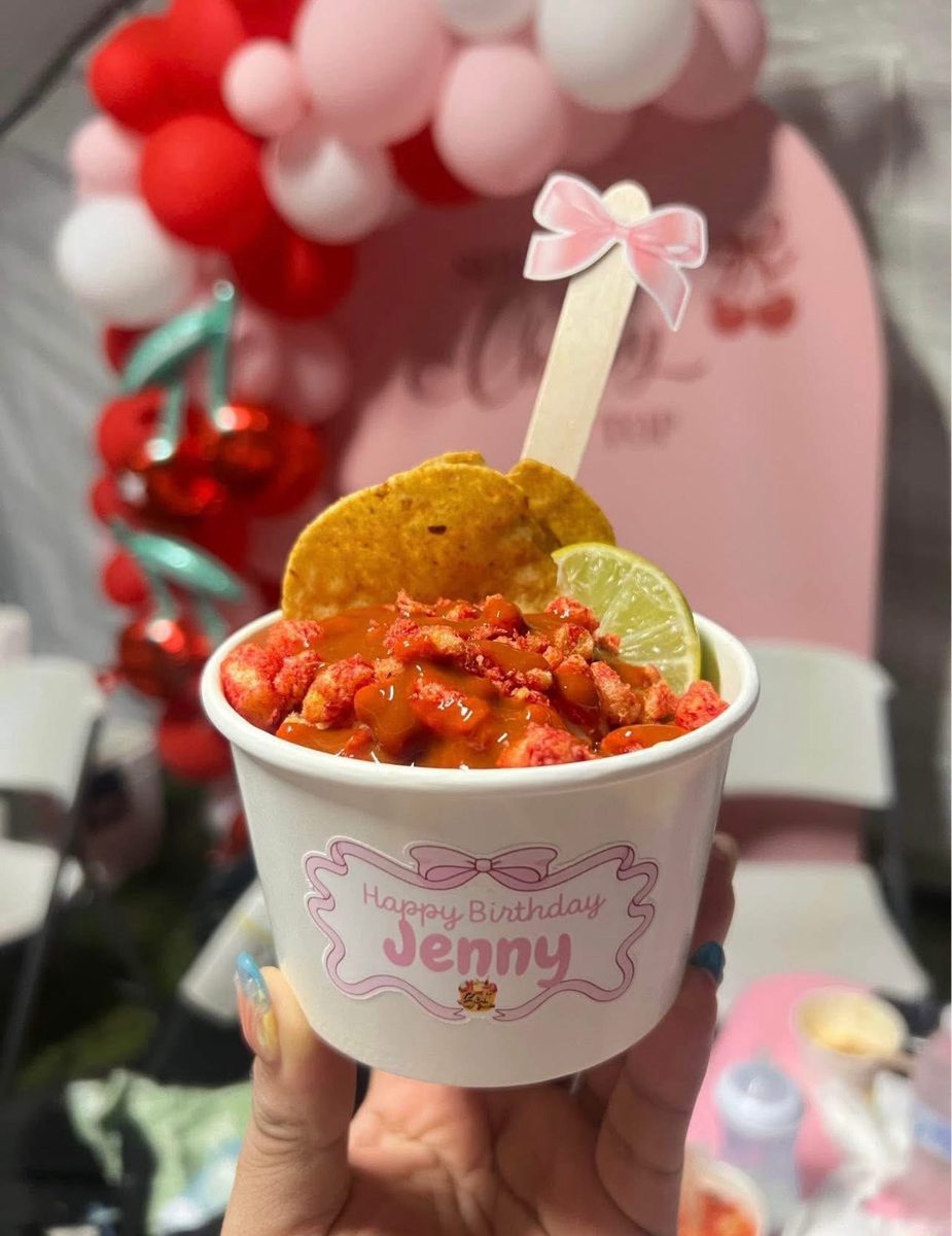 Cup of esquites Mexican street corn with a tortilla chip and lime