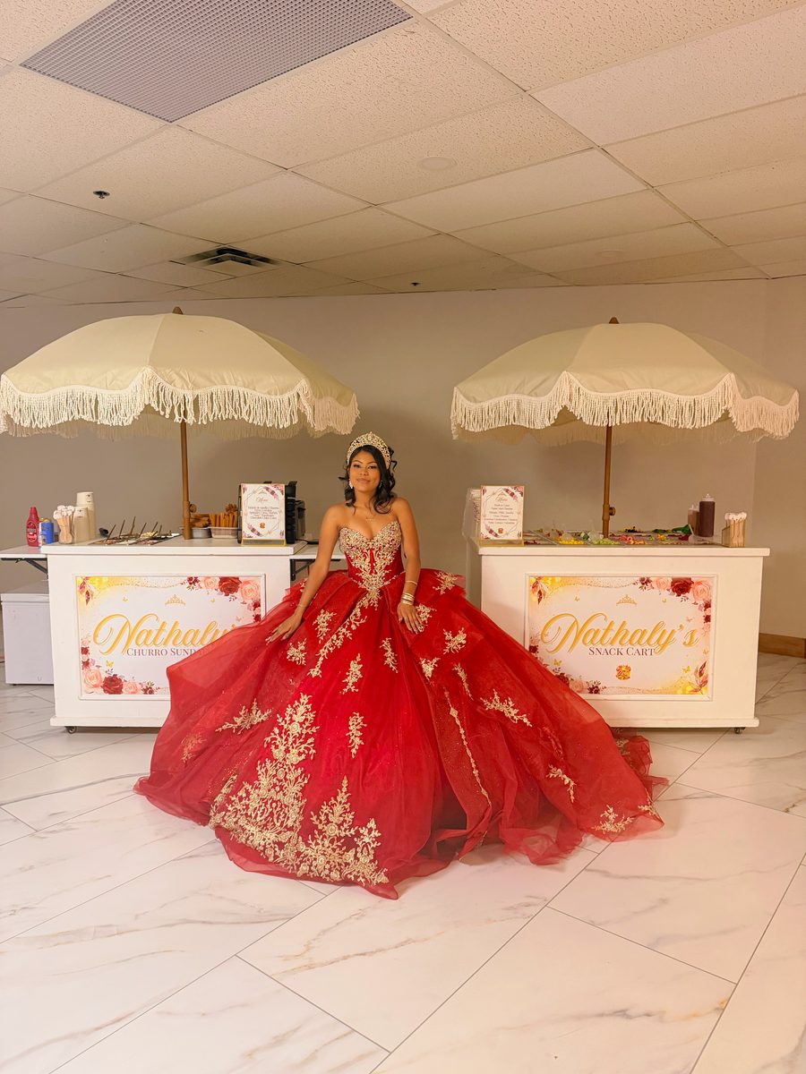 Quinceañera in a red gown beside two Geli Snacks snack carts at her celebration