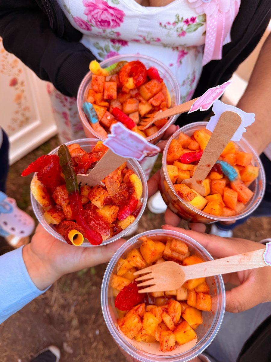 Friends holding up colorful Geli Snacks fruit cups at a celebration