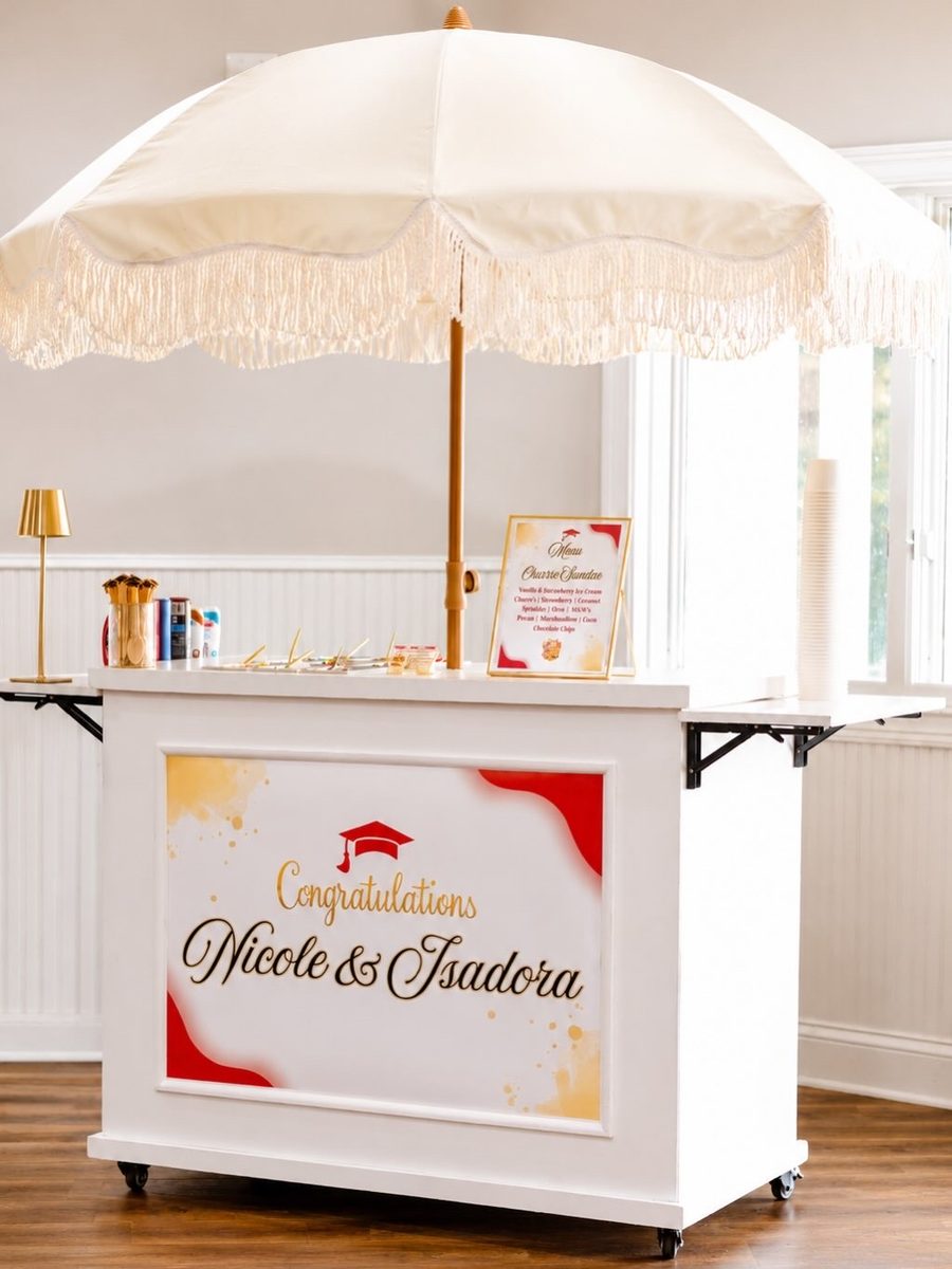 Geli Snacks white snack cart with a fringed umbrella set up for a graduation celebration